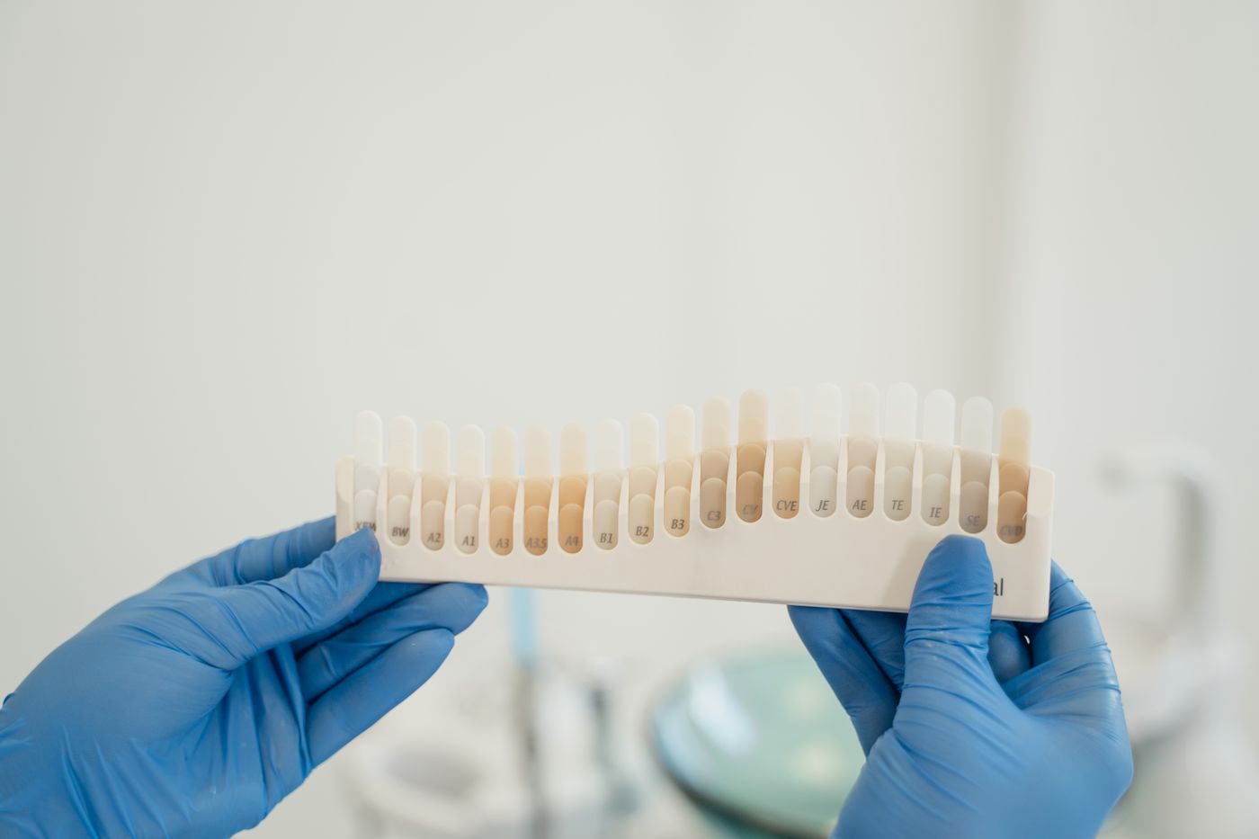 A tooth shade guide held up to match a restoration
